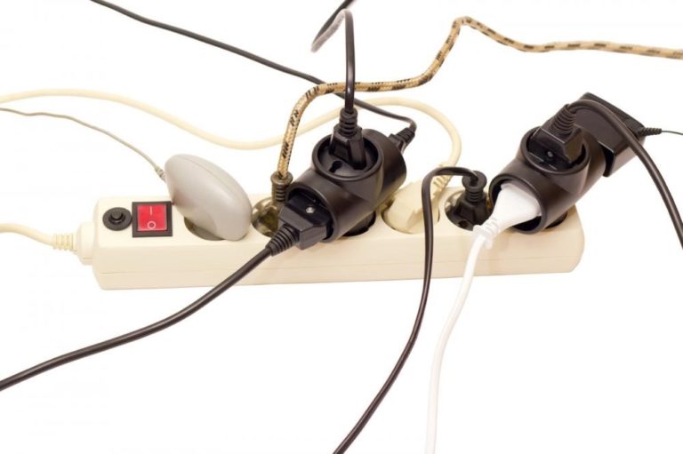 a surge protector with all of its outlets in use and wires going in different directions