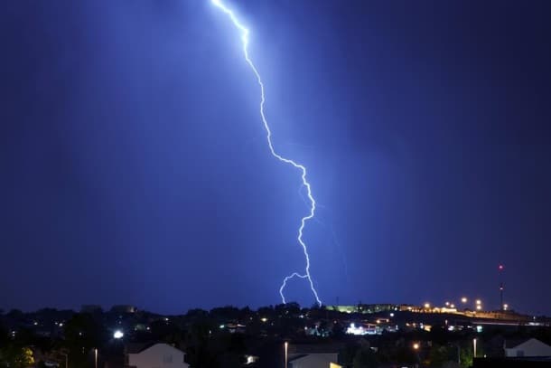 lightning bolt over a neighborhood at night