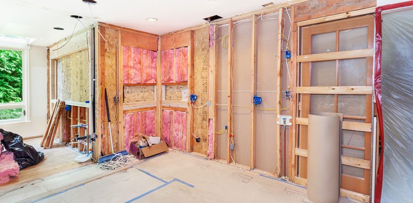 kitchen in the middle of being remodeled with exposed wiring and insulation